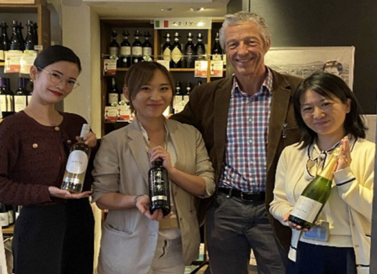 William Long with 21 Community in Japan holding bottles of wine