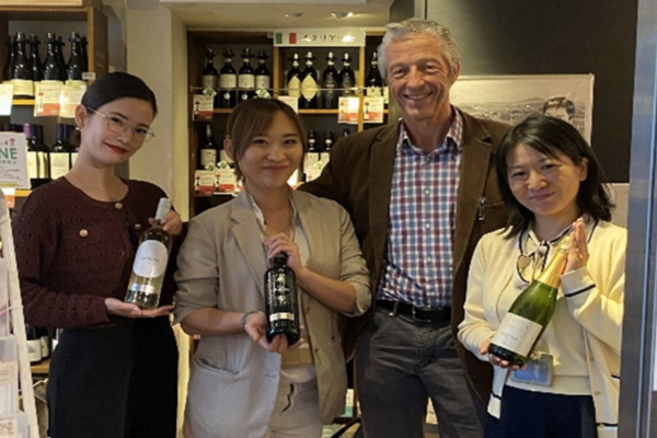 William Long with 21 Community in Japan holding bottles of wine